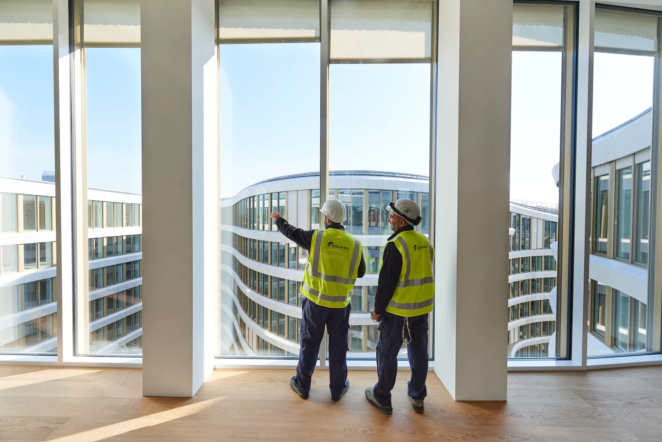 hommes regardant à travers les fenêtres d'un building