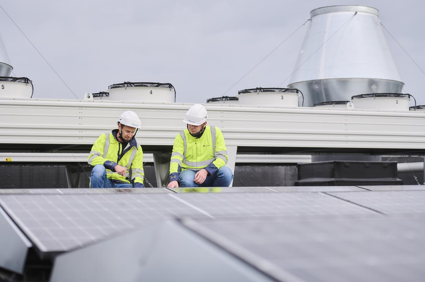 deux collègues d'Equans qui travaillent sur le toit du bâtiment du labo de UA