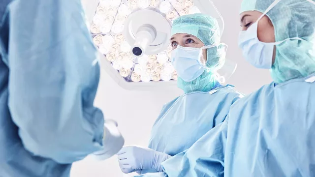 Personnel en blouse dans salle d'opération