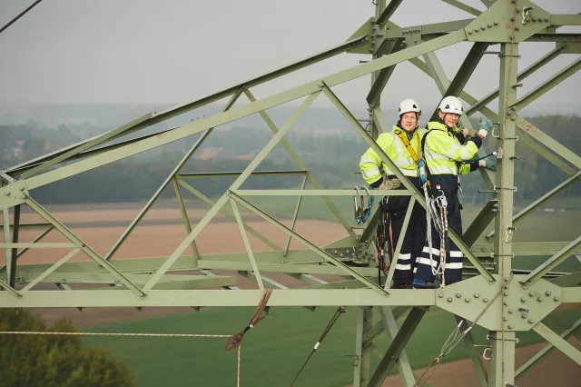 hommes travaillant sur pylône électrique 